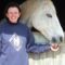 Kay Alty New Yatt RDA Kay Alty of New Yatt Riding for the Disabled Association, giving a treat to a fleabitten grey horse