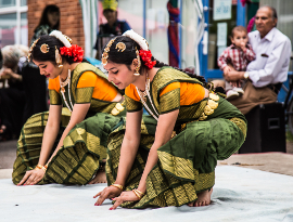 Traditional Indian dancers dressed in green and yellow saris, at the Oxford Mela festival
