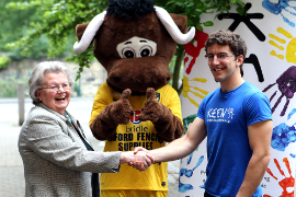 OCF trustee Lady Stephanie North shaking hands with a representative from children's charity Keen, with the Oxford United football mascot behind them