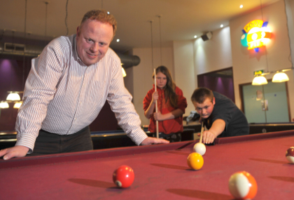 Richard Colbrook, project leader of the Leys Youth Programme, watches beneficiaries Charley and Leo play pool