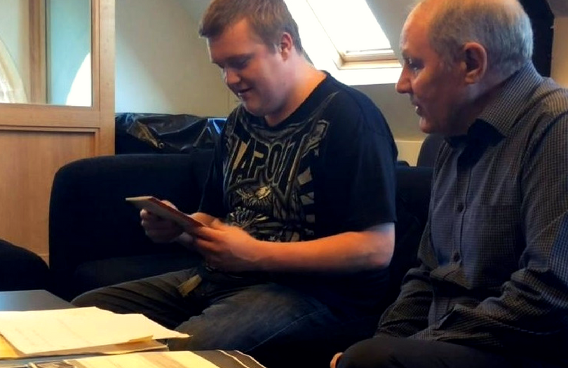 A mentor helps a young man read