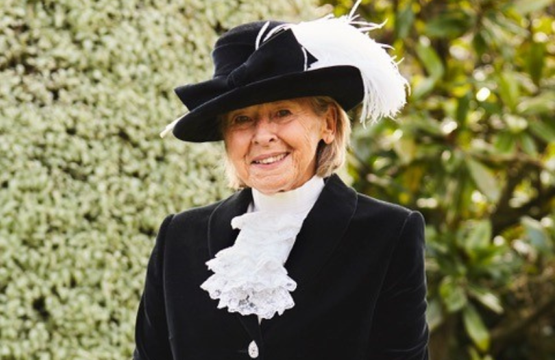 Sally Scott High Sheriff 810×525 Sally Scott, the new High Sheriff of Oxfordshire, is smiling and wearing her ceremonial uniform which consists of a black velvet coat, white shirt with lace ruffles and a black hat with white feathers.