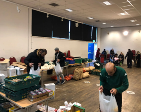 People packing food parcels in a hall