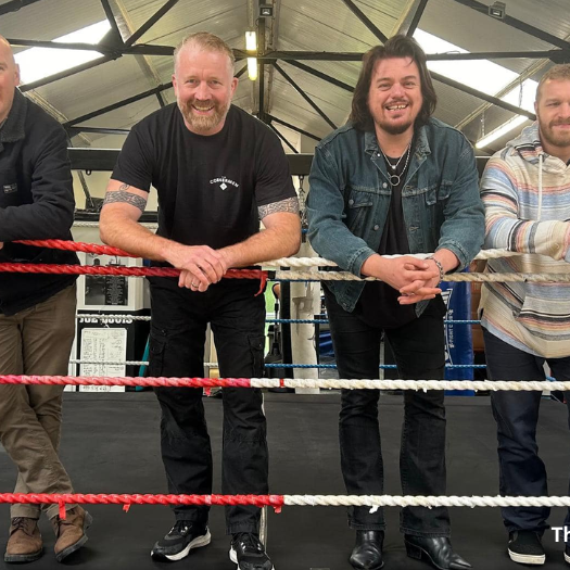 The Cornermen 810×525 Four smiling men in a boxing ring with caption: "The Cornermen"