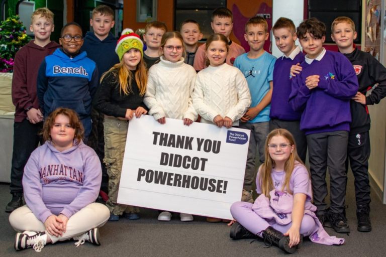 A group of children holding a sign saying 'thank you Didcot Powerhouse!'