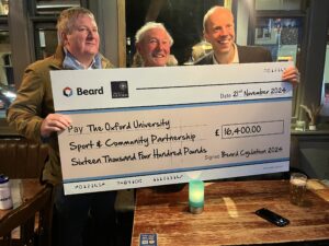 Three men holding a giant cheque from Beard for £16,400.