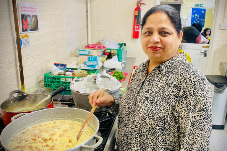 Sunrise Multicultural centre 1 Woman standing in front of a saucepan, stirring her cooking.