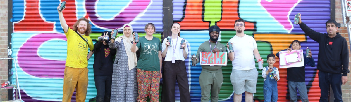 Donor-advised fund web page 1200350 Group of people standing in front of some graffiti artwork saying 'Rose Hill'.