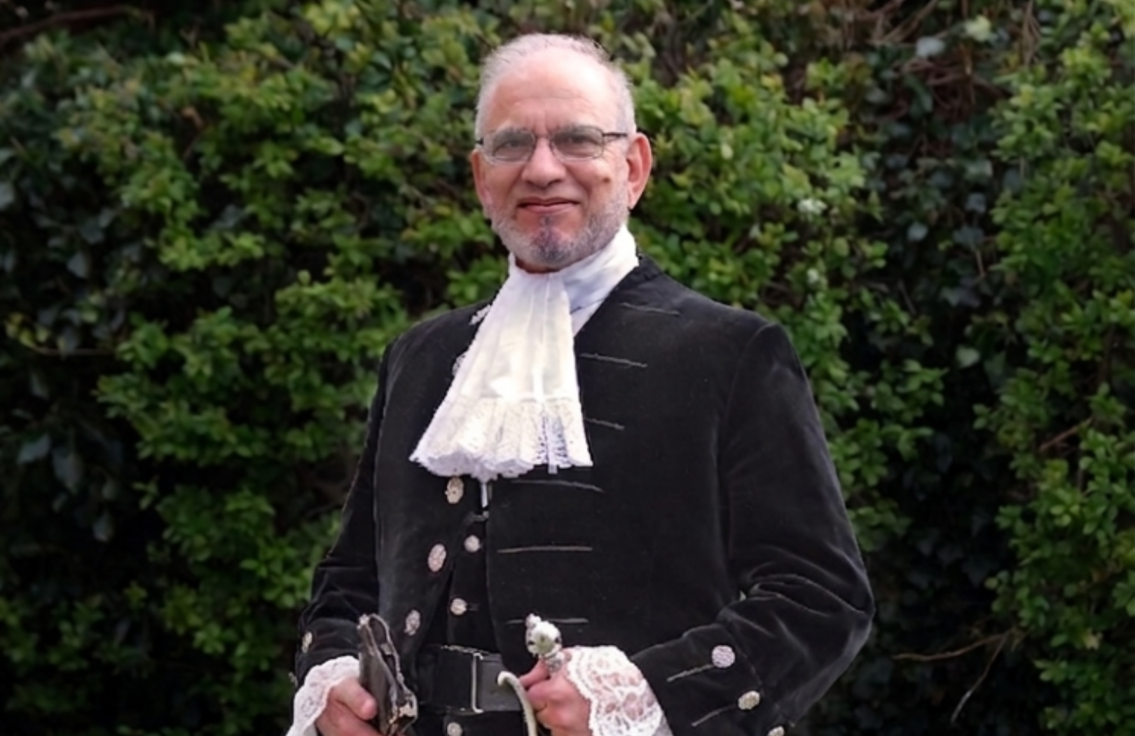 The High Sheriff, Jawaid Malik, dressed in the High Sheriff traditional uniform of black decorated jacket and lace shirt.