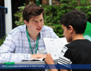 A man listens to a child reading