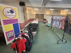 Clothes rails with pre-loved school uniform hanging up.
